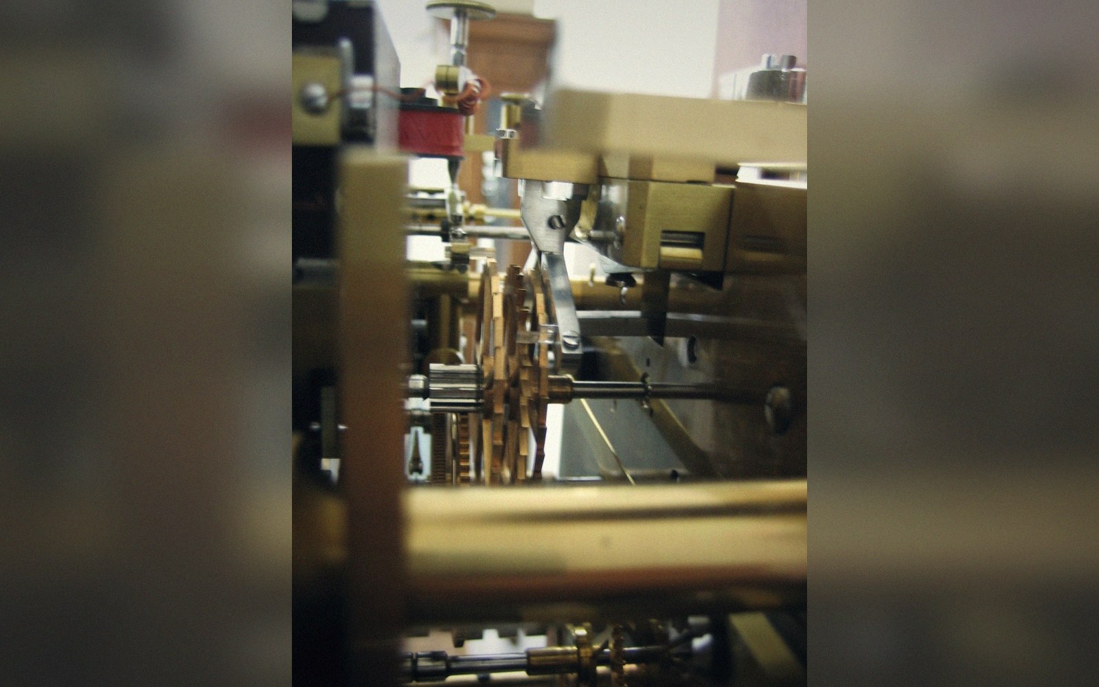 Extreme close on an anchor escapement engaging an escape wheel, pallets and teeth sharp, everything else falling away